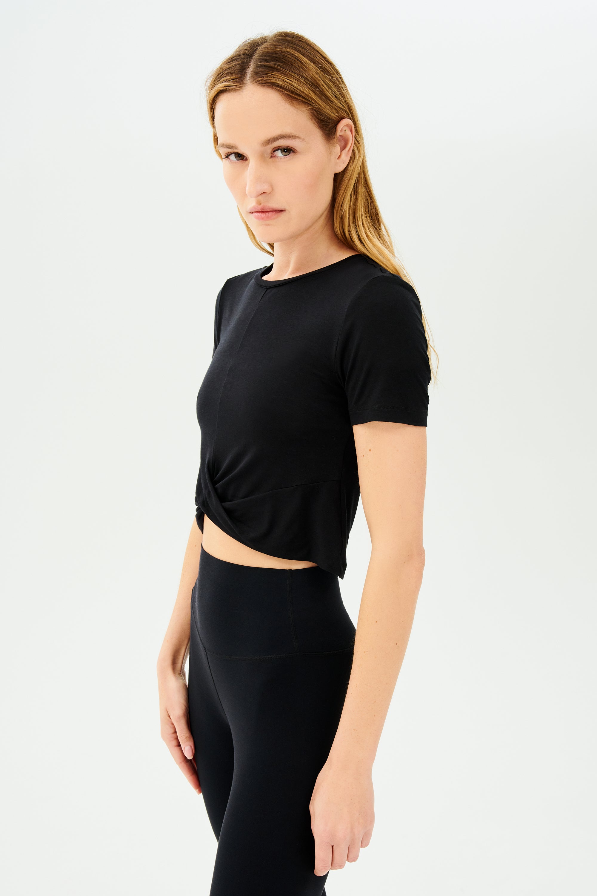 The model is wearing high-waist leggings and a SPLITS59 black crop top.