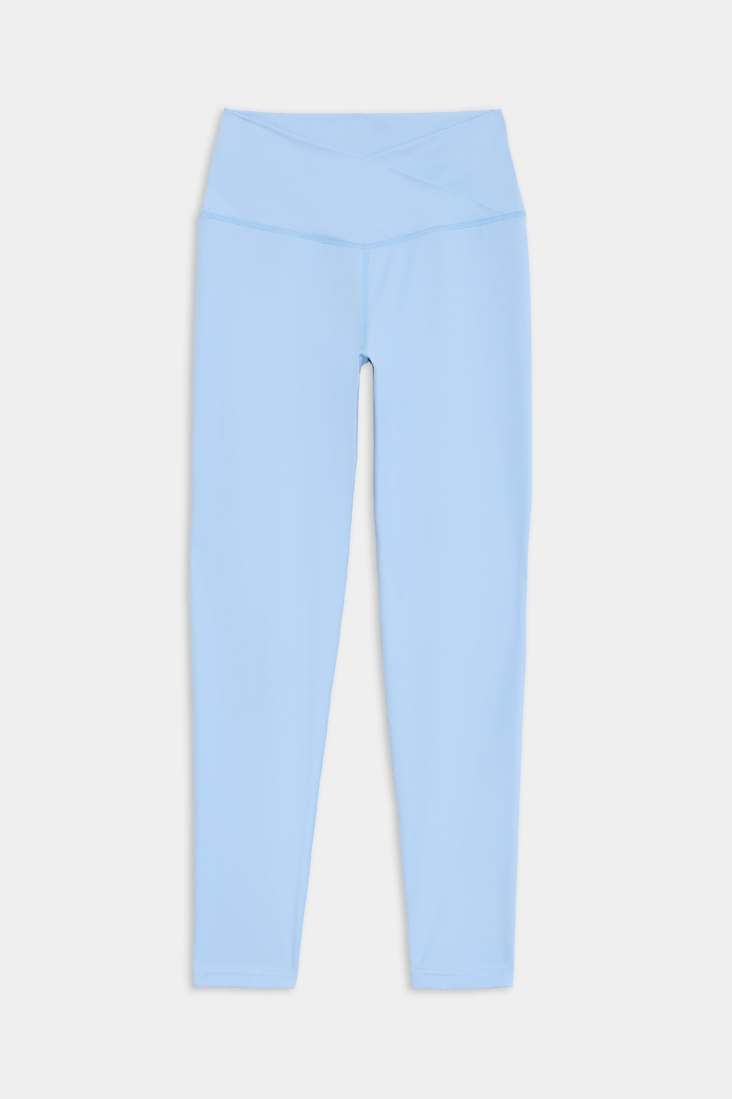 Light blue high-waisted leggings with a crossover waistband, made of a comfortable nylon-spandex blend, displayed on a white background. Product: Mia Rigor 7/8 - Skylight by SPLITS59.