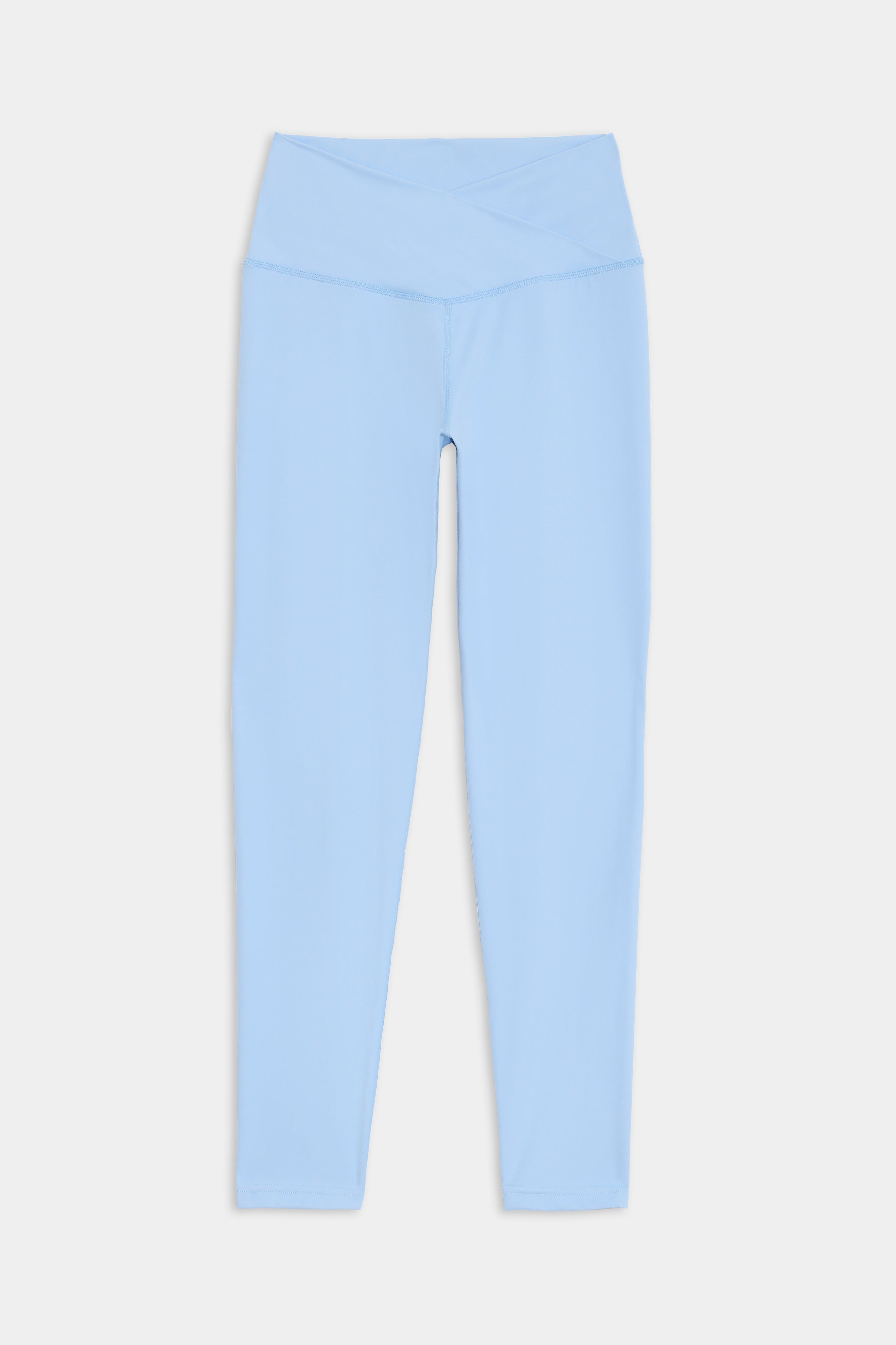 Light blue high-waisted leggings with a crossover waistband, made of a comfortable nylon-spandex blend, displayed on a white background. Product: Mia Rigor 7/8 - Skylight by SPLITS59.