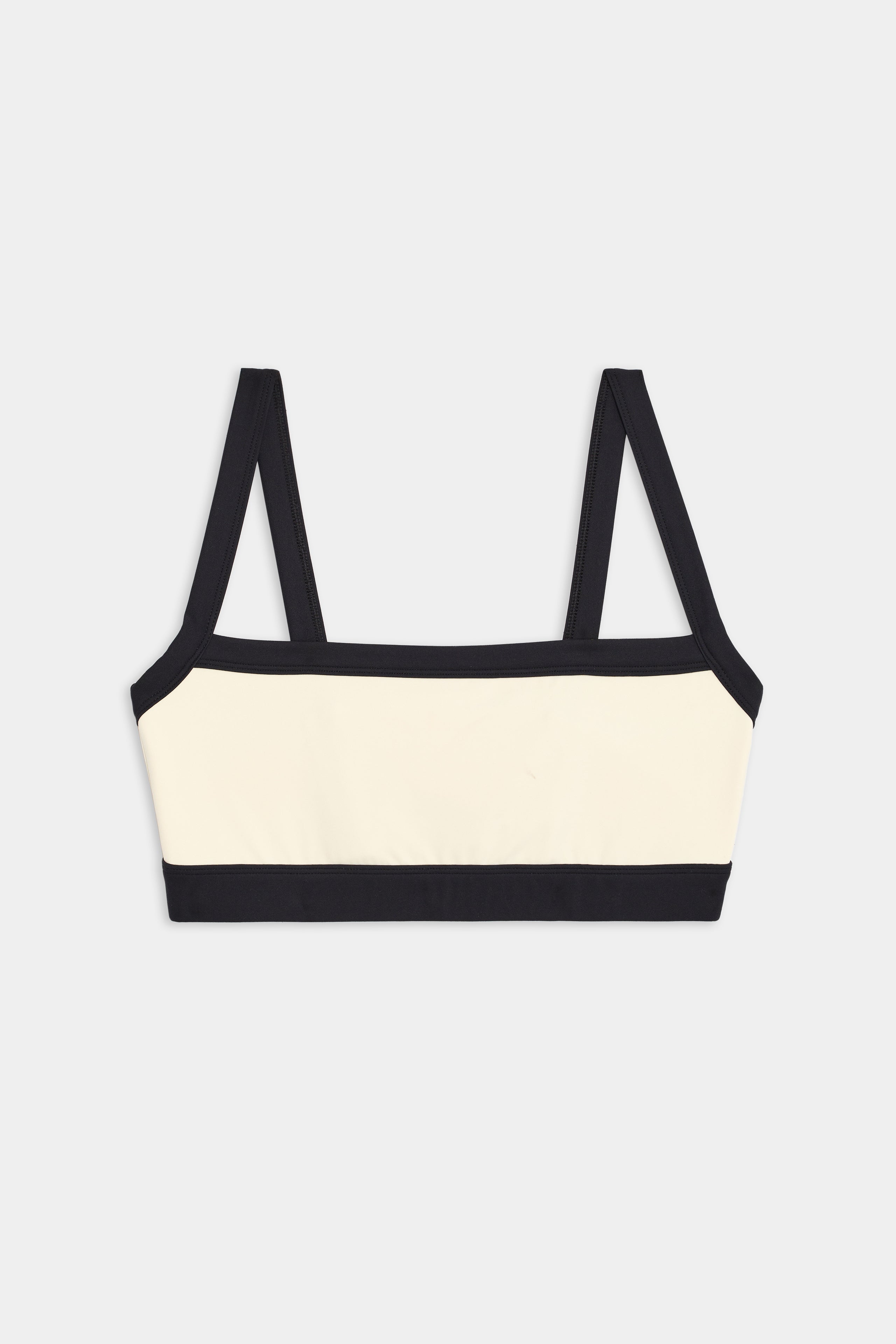 A Monah Rigor Bra by SPLITS59, featuring a cream color with black straps and trim, perfect for gym workouts, is laid flat on a white background.