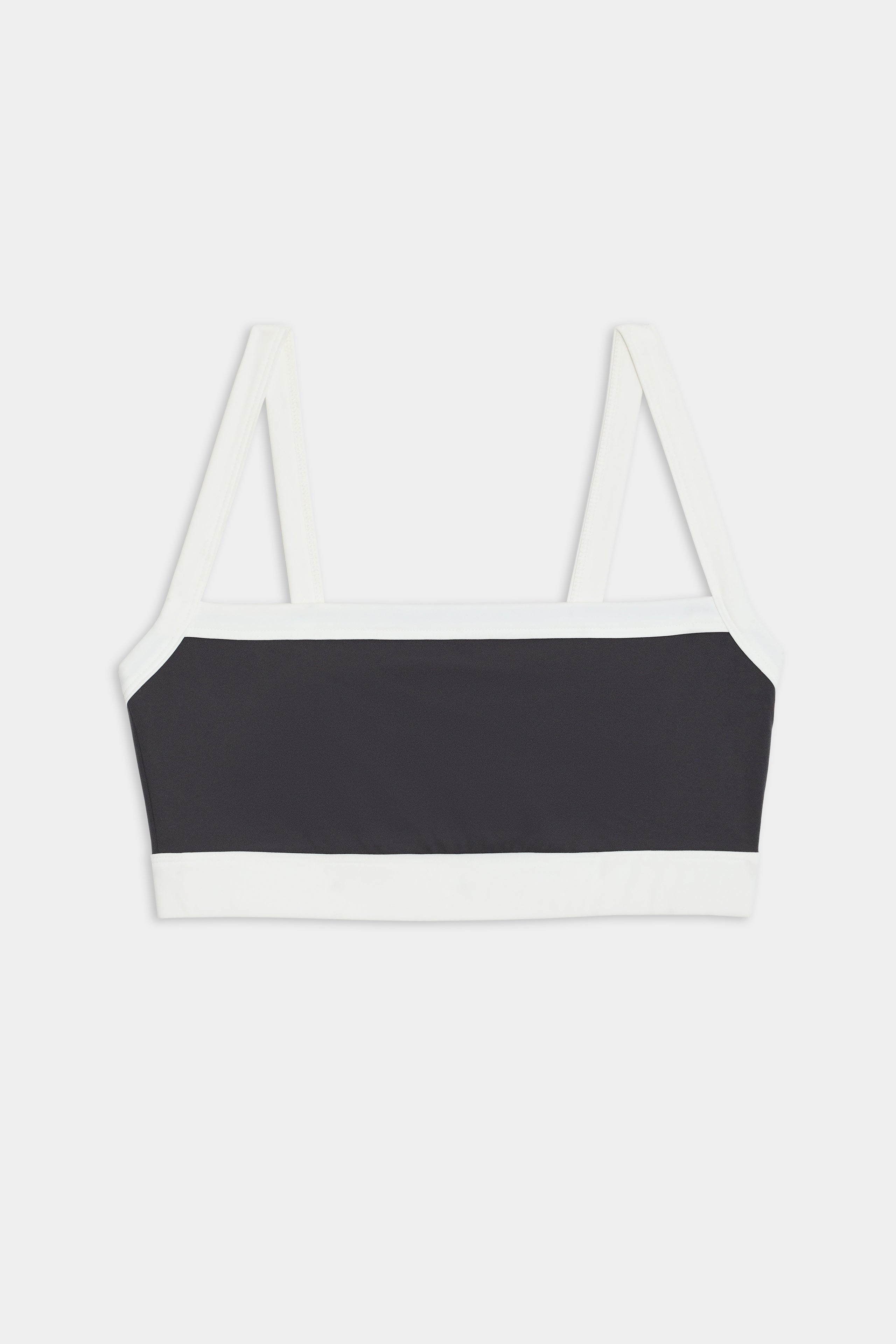 The Monah Rigor Bra by SPLITS59 features a black and white colorblock design with white straps and trim, set against a plain white background.