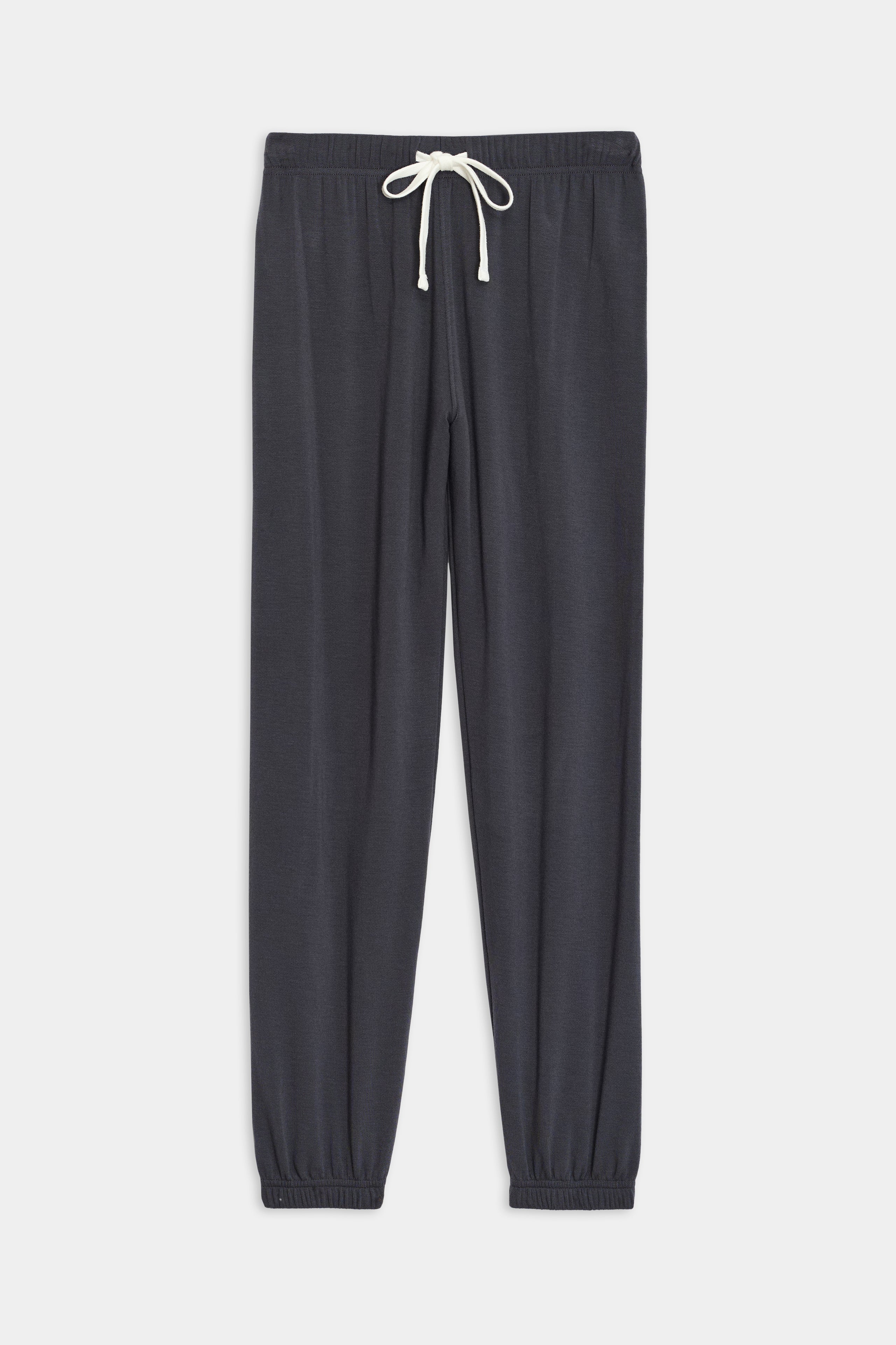 The Sonja Fleece Sweatpant by SPLITS59 in graphite: black, ultra-luxe fleece sweatpants with an adjustable white drawstring waist and elastic ankle cuffs, laid flat on a white background.