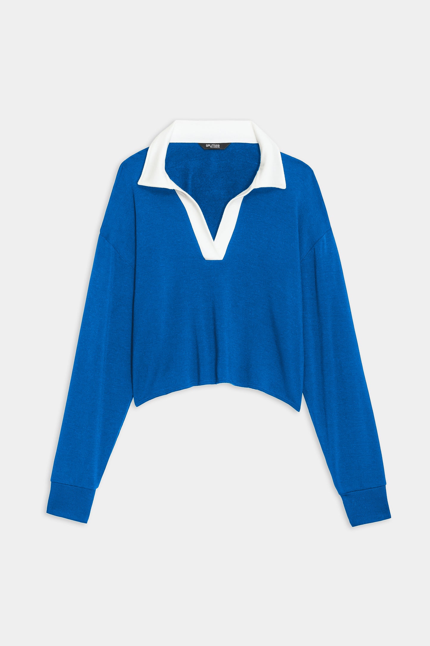 The Joan Fleece Polo Sweatshirt by SPLITS59 is a blue long-sleeve crop top with a white collar and split neckline, displayed on a plain white background.