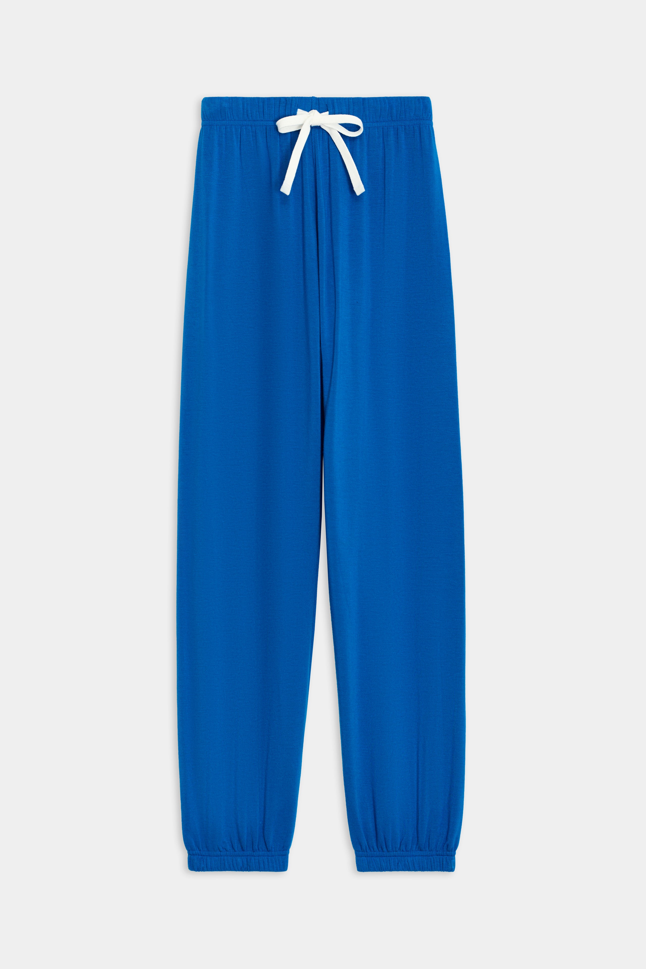 The SPLITS59 Andie Oversized Fleece Sweatpant in Classic Blue is perfect for cool weather workouts, featuring a white drawstring, elastic waistband, ankle cuffs, and is proudly MADE IN LOS ANGELES.